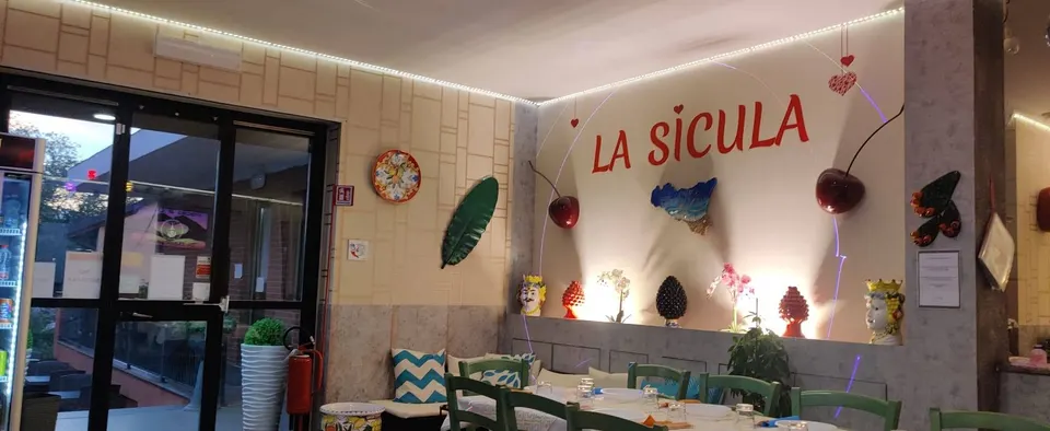 La sala del ristorante con la scritta rossa La Sicula sulla parete